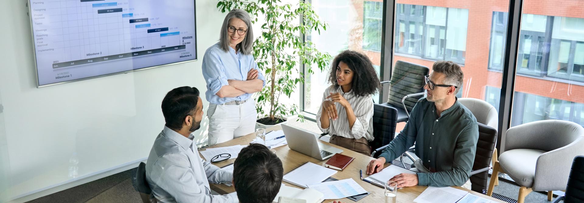 Project manager leading a team meeting in an office room. 